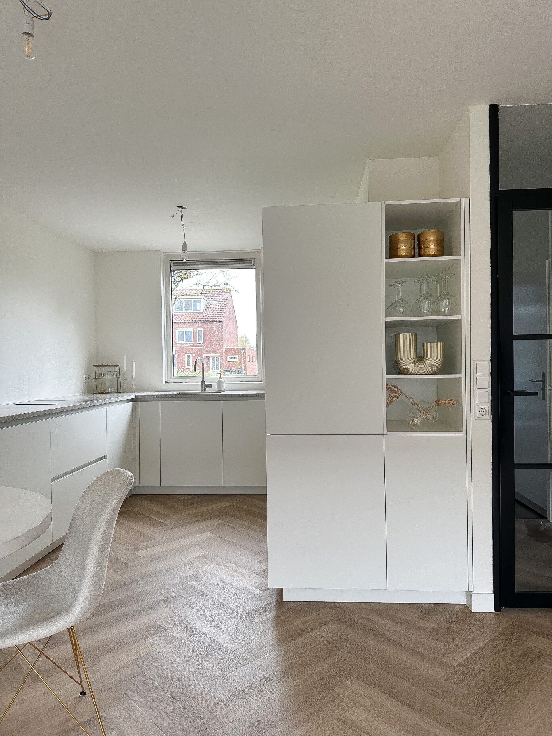 Visgraat laminaat vloer in een moderne witte keuken.