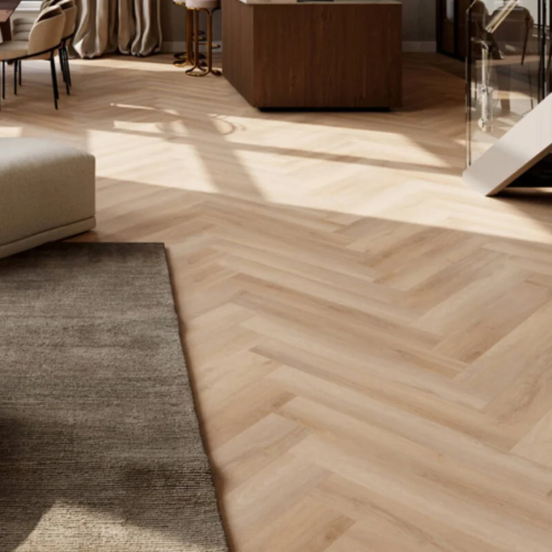 Lichte visgraat vloer in open woonconcept met een woonkamer, keuken en trap naar boven.