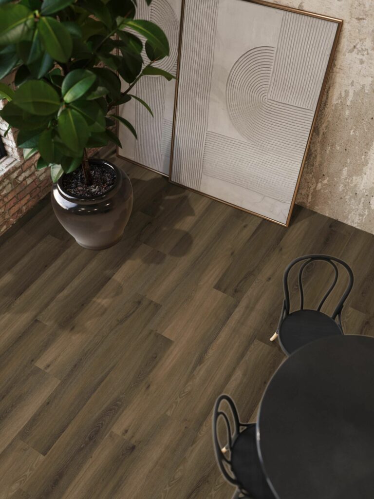 Donkerbruine houten vloer met zwarte tafel en kamerplant.