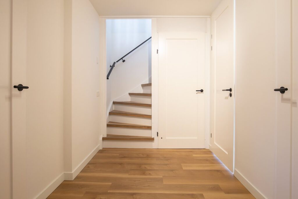 PVC vloer in een half met witte plinten.